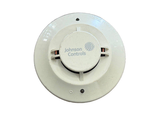 Johnson Controls fire alarm smoke detector, white circular device with visible wiring terminals