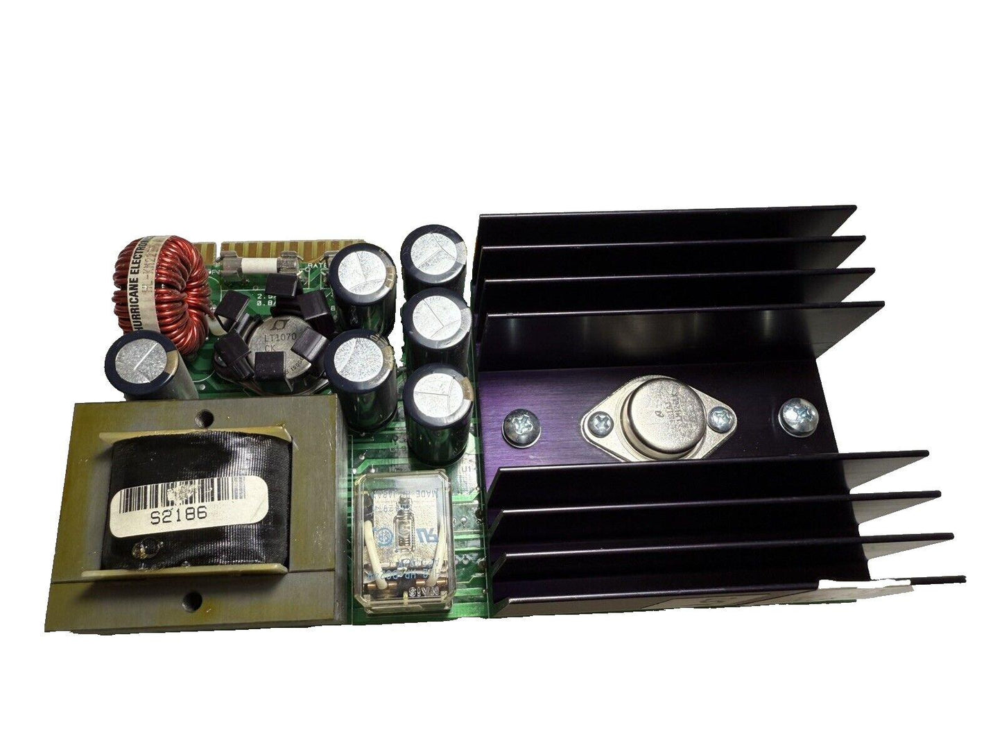 Fire alarm control panel circuit board with capacitors, heatsink, and transformer for fire safety systems