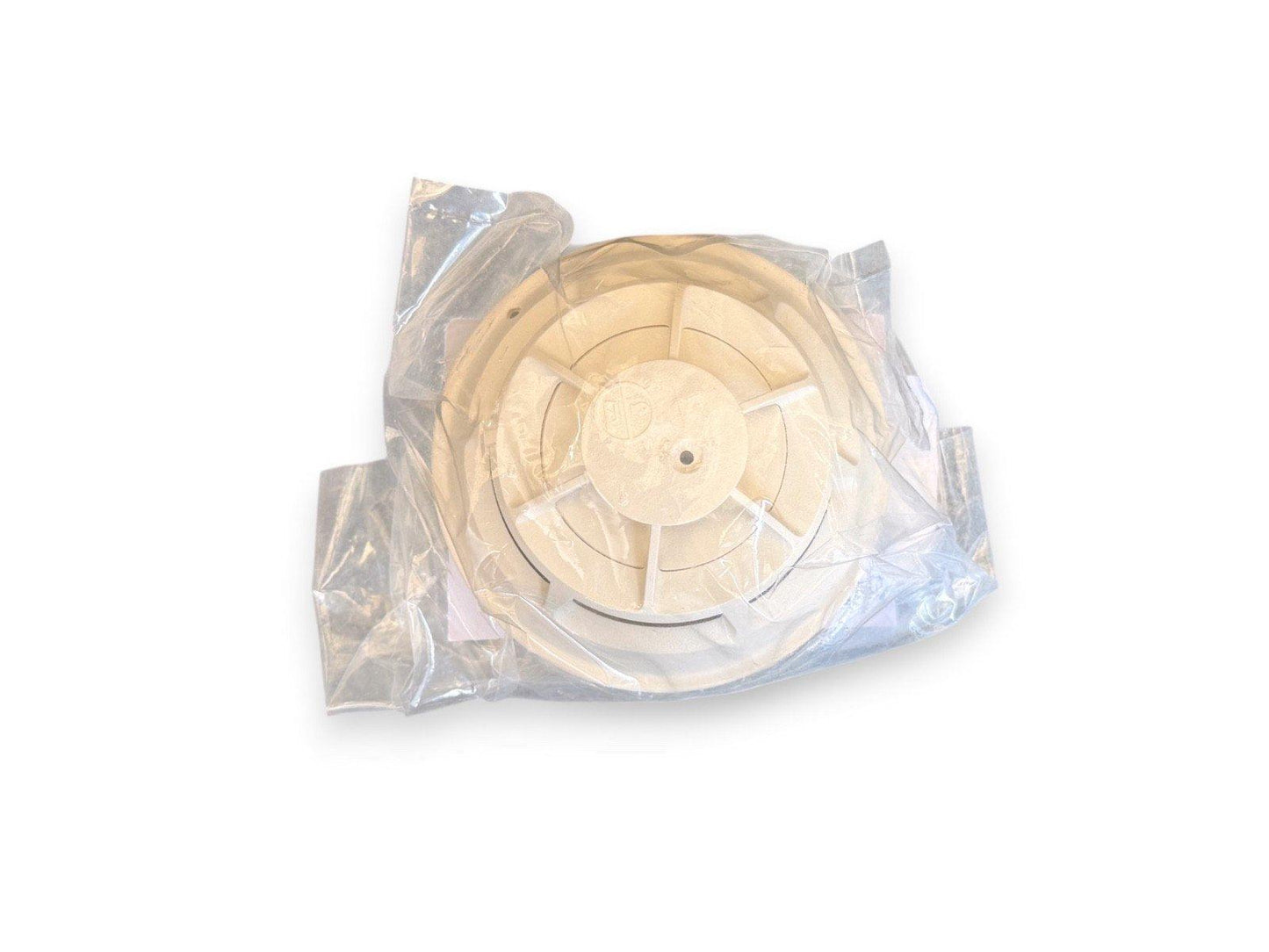 Beige fire alarm base in clear plastic packaging, new fire safety equipment