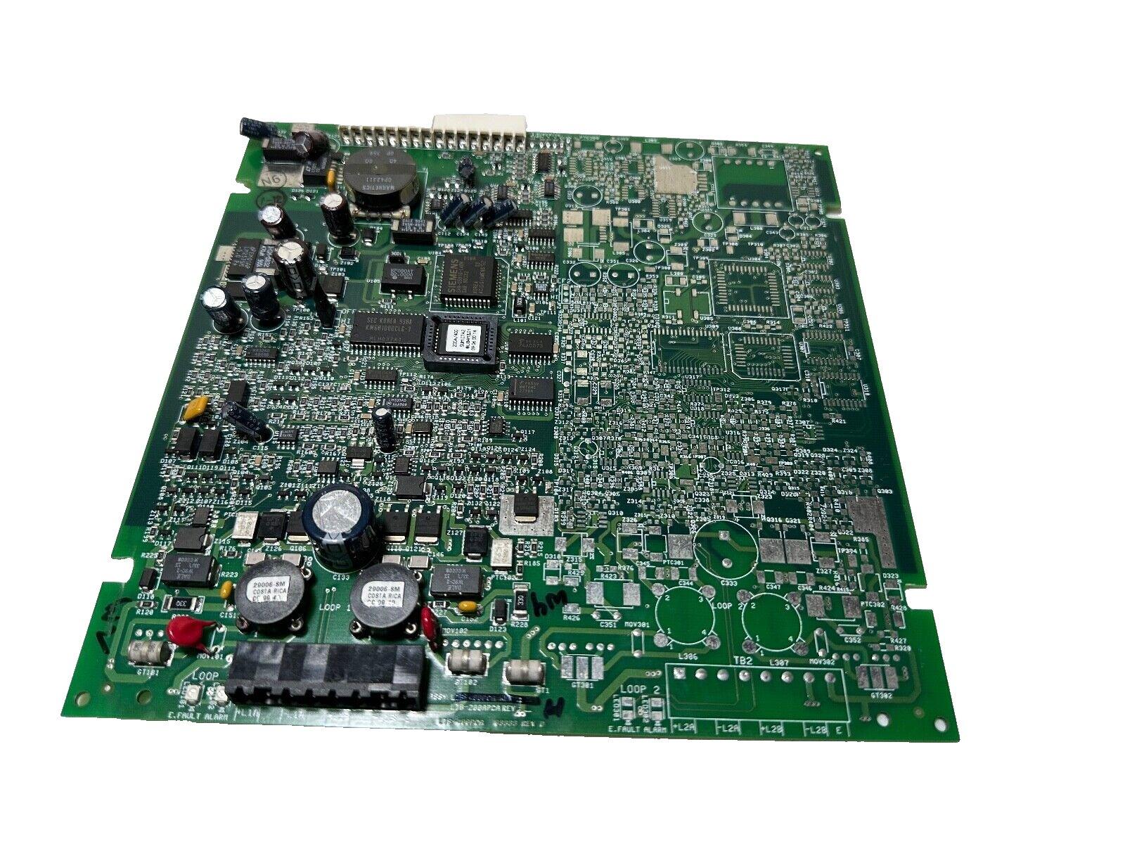 Fire alarm control panel circuit board with capacitors, chips, and loop connectors for fire safety systems