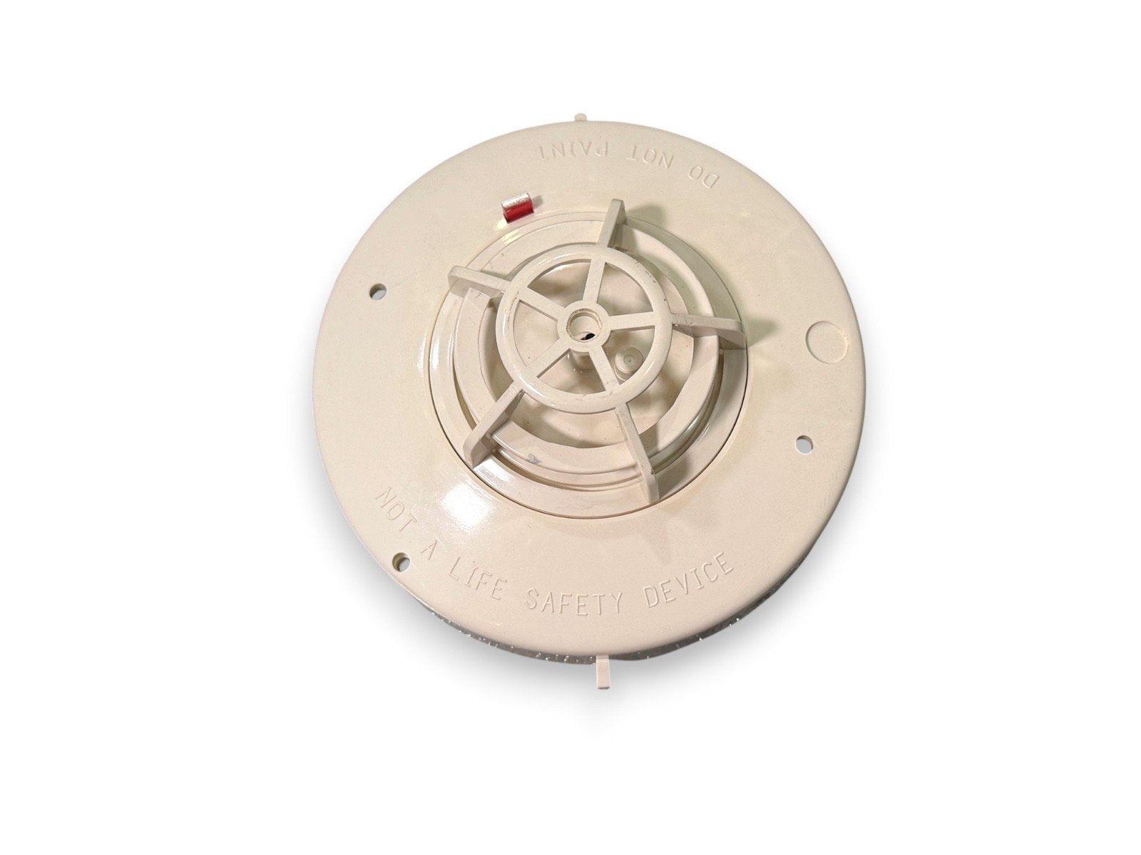 Beige ionization smoke detector base with red test button, labeled 'DO NOT PAINT' and 'NOT A LIFE SAFETY DEVICE'