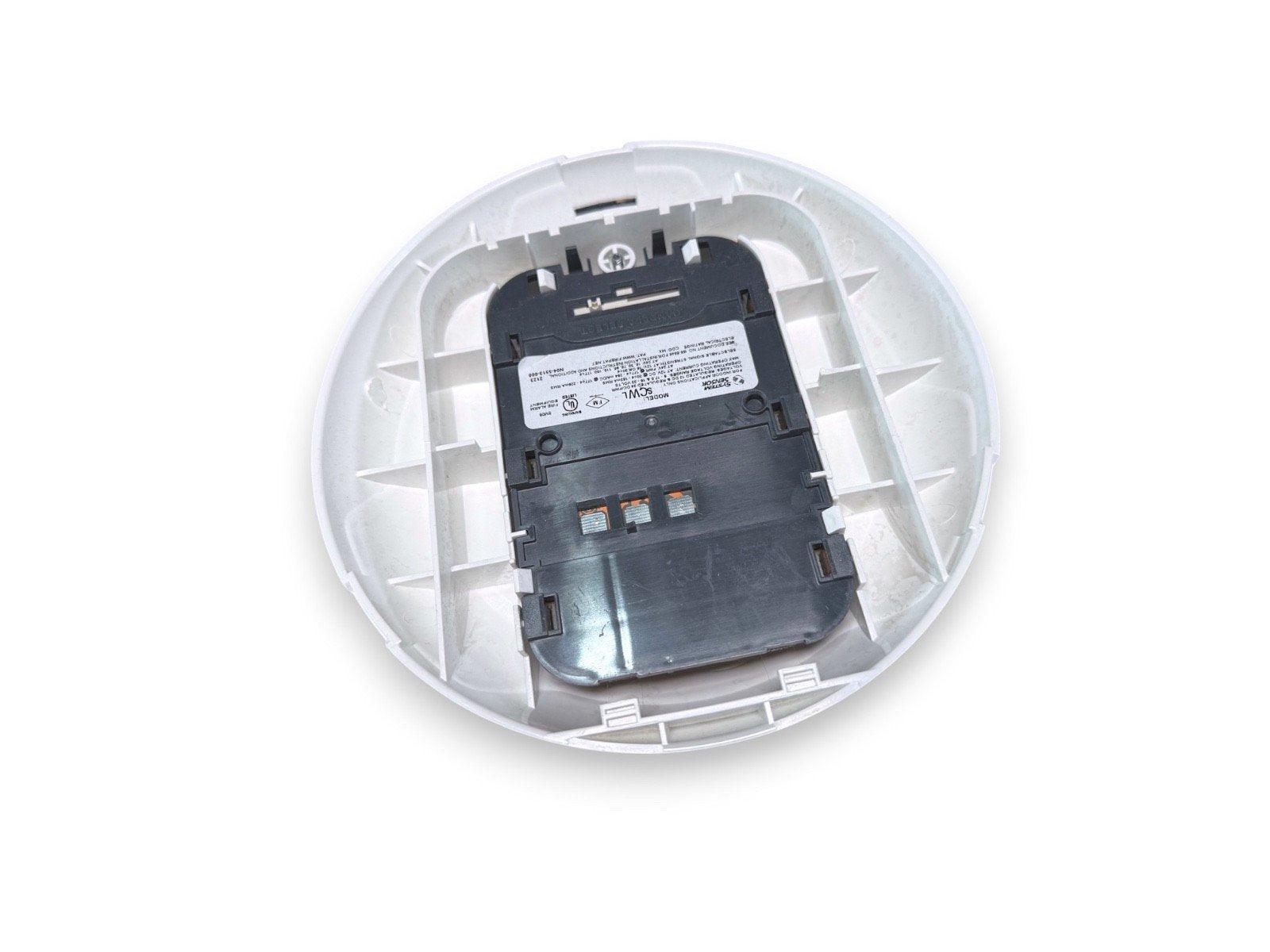 White fire alarm detector base with black mounting plate and wiring terminals, shown from above