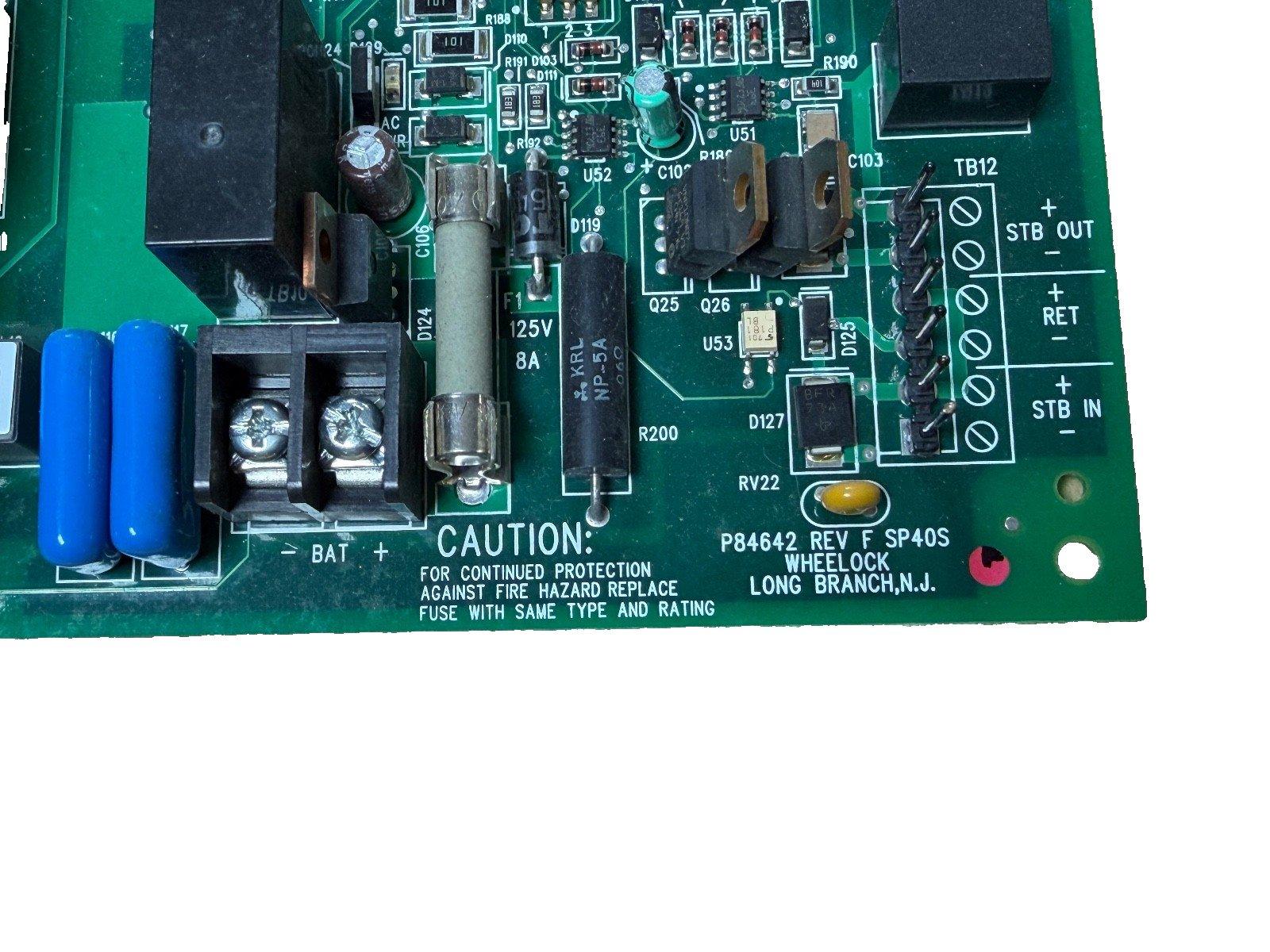 Fire alarm control panel circuit board with fuse, capacitors, and terminal connections for STB IN/OUT