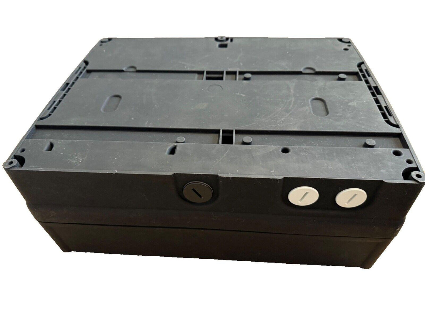 Black fire alarm control panel with mounting slots and terminal screws, used fire safety equipment