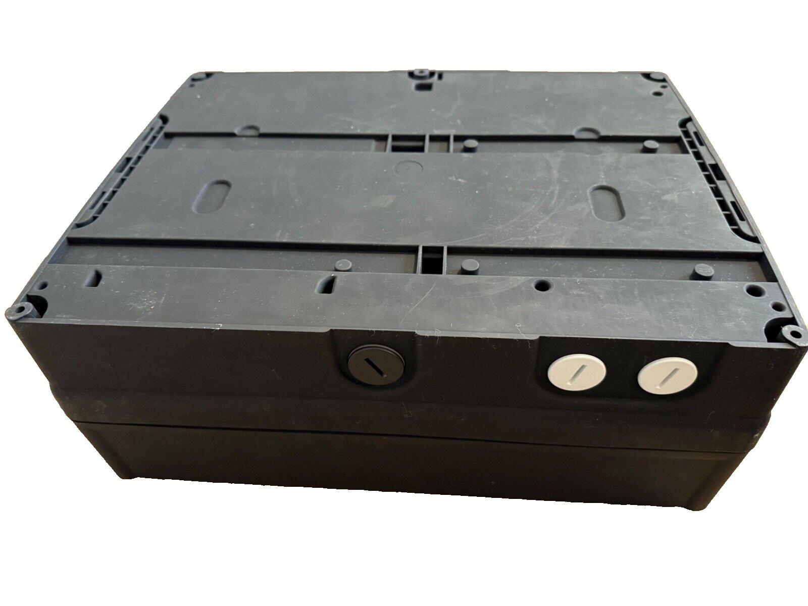 Black fire alarm control panel with mounting slots and terminal screws, used fire safety equipment