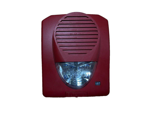 Red fire alarm horn strobe with clear lens and speaker grille for emergency warning systems