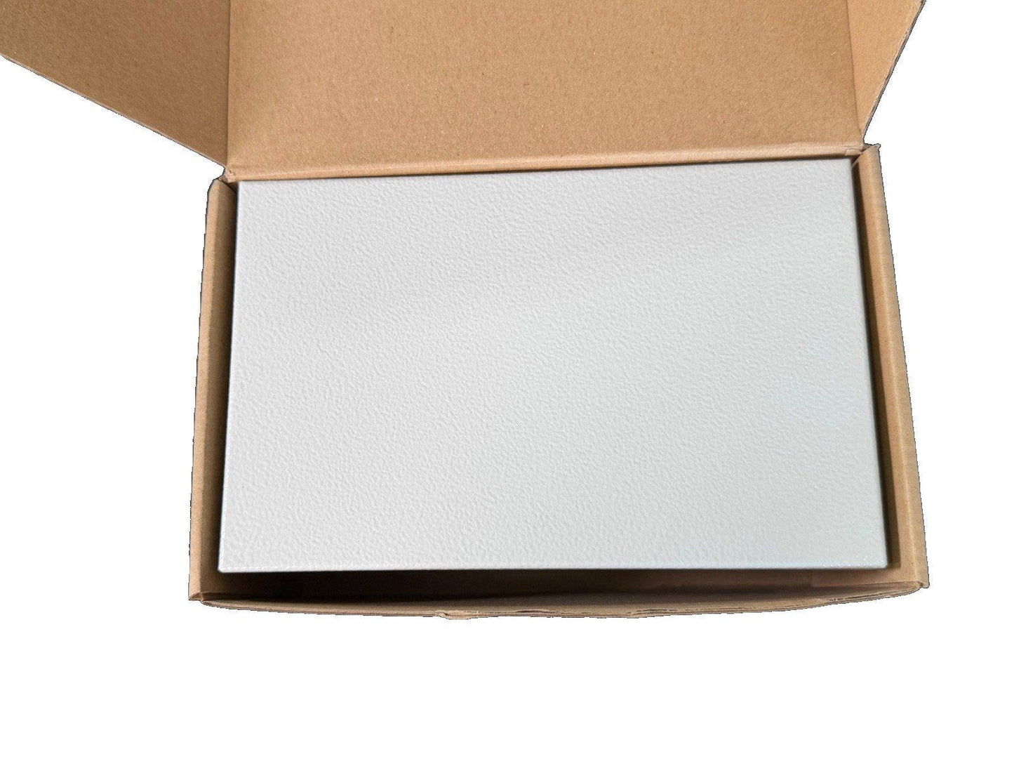 White fire alarm control panel in open cardboard box, ready for installation