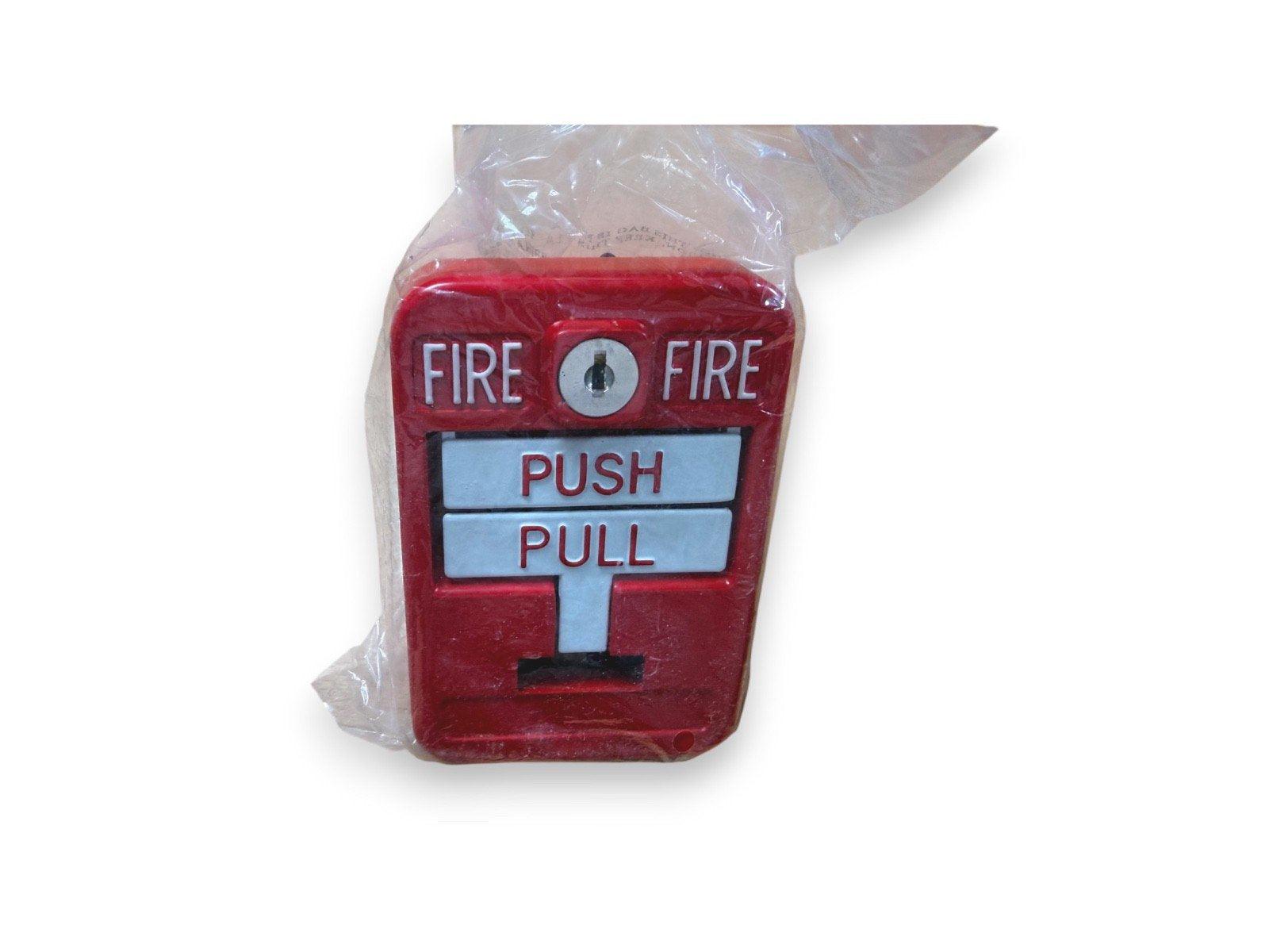 Red fire alarm pull station with push/pull lever, wrapped in plastic for shipping