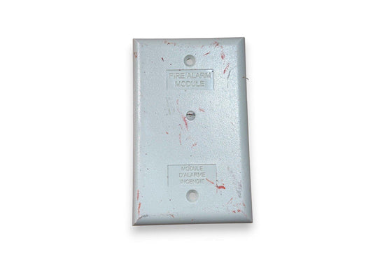 Used fire alarm module with bilingual labeling, showing wear and red marks on metal surface