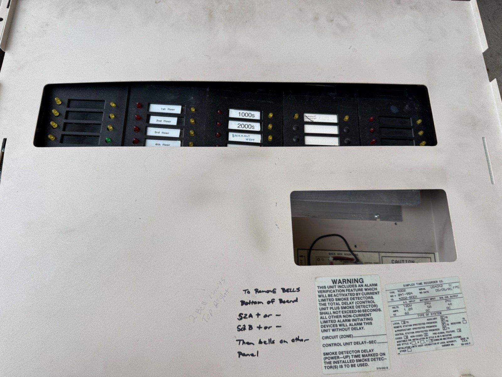Used fire alarm control panel with floor zone indicators and warning labels for smoke detector delay settings