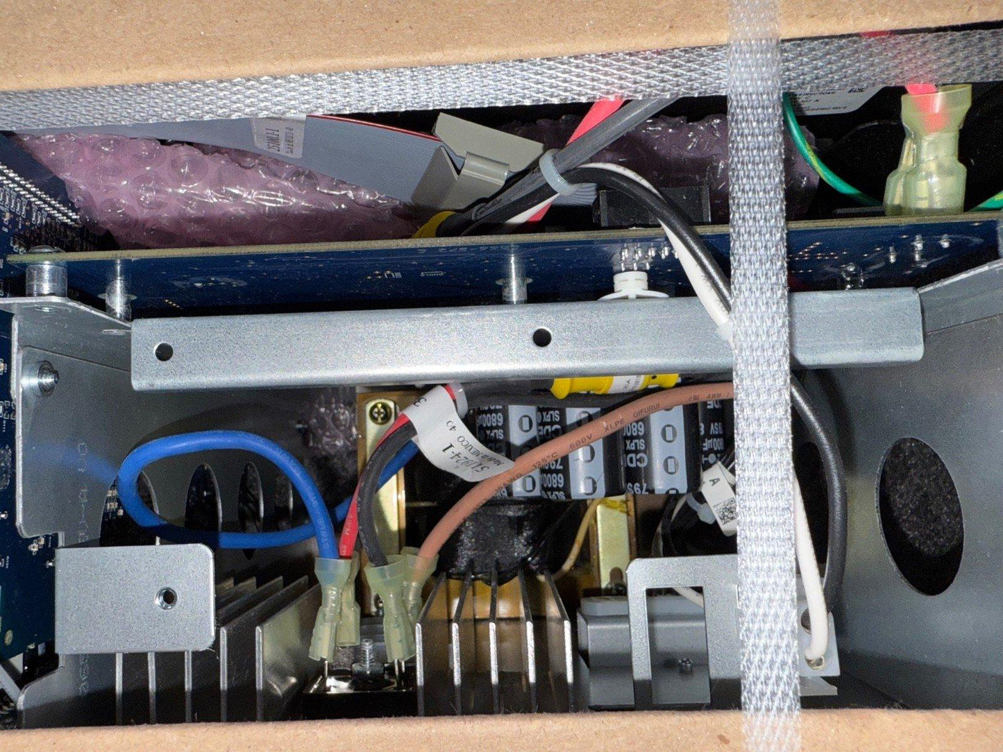 Fire alarm control panel interior with wiring, capacitors, and circuit board components visible