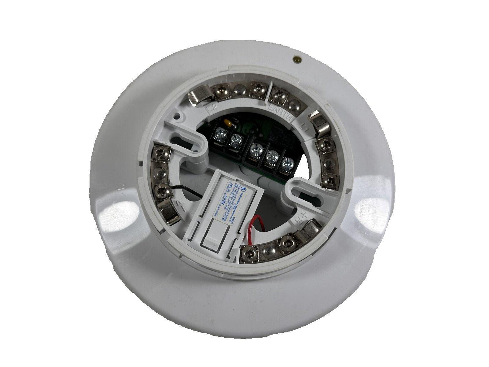 White fire alarm detector with exposed wiring terminals and battery compartment for installation