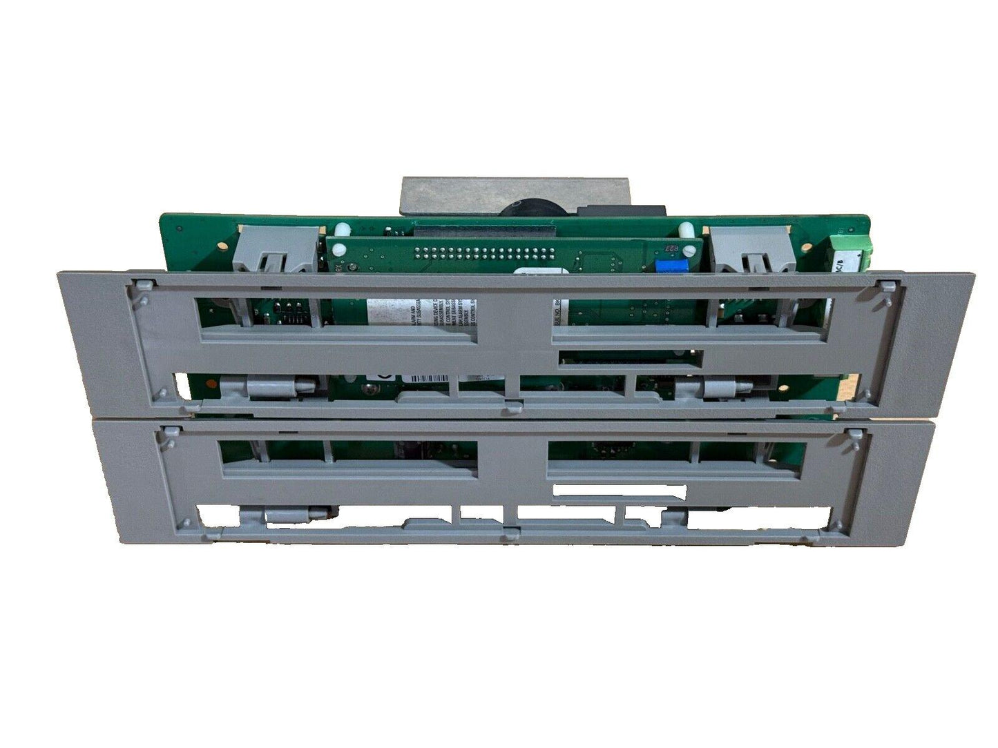 Fire alarm control panel circuit board with gray housing and green PCB components