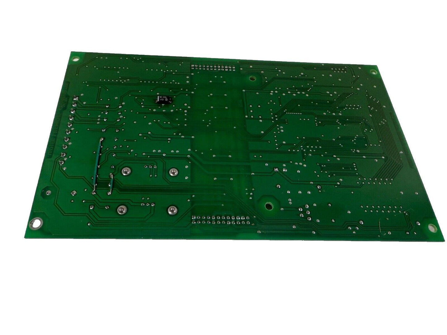 Green fire alarm control panel circuit board with solder points and connectors