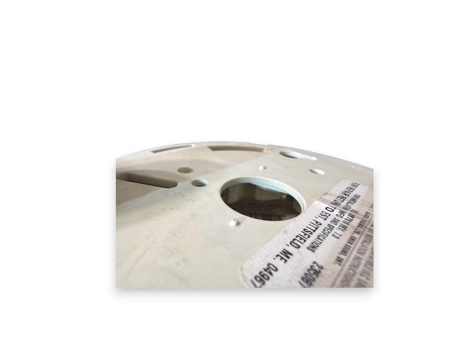 White fire alarm base with installation label, used fire safety equipment