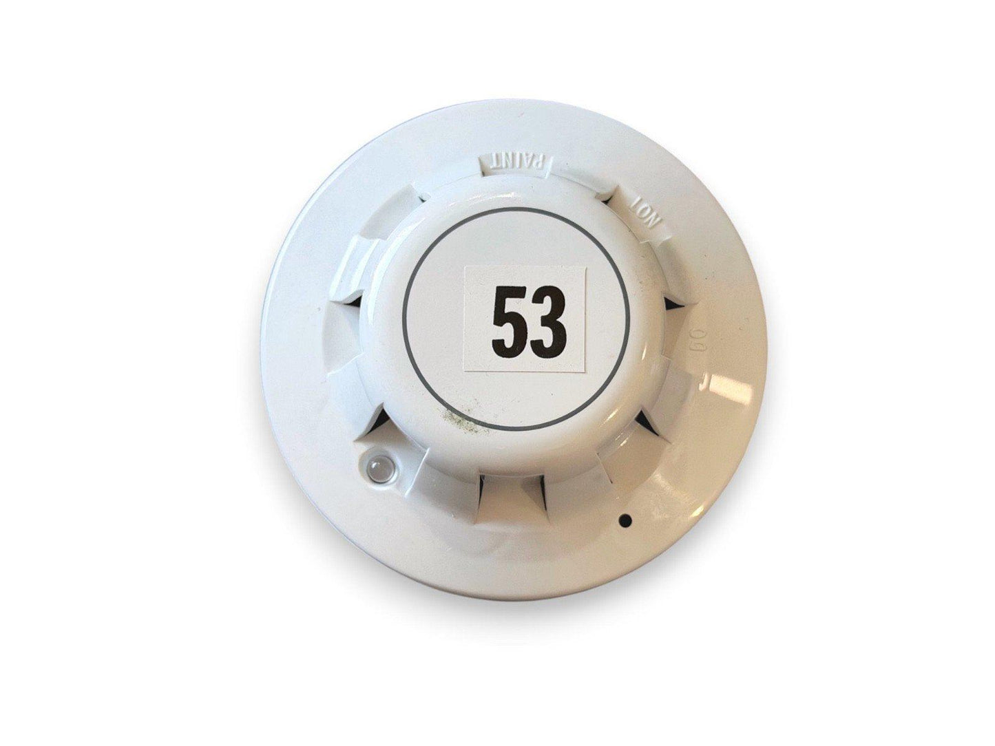 White fire alarm detector with label 53, used fire safety equipment