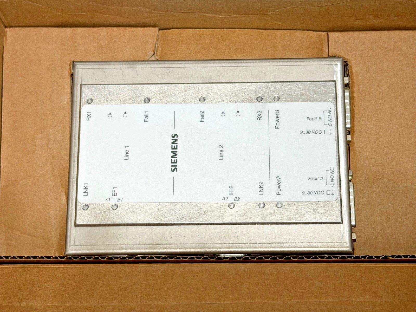 Siemens fire alarm control module with labeled terminals, power inputs, and fault indicators in cardboard box