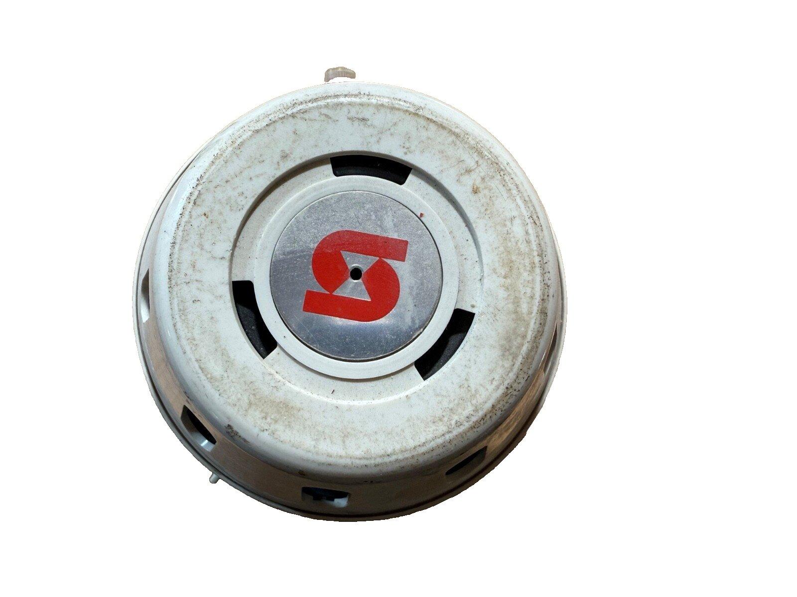 Used fire alarm horn with red logo, circular white housing, and mounting slots