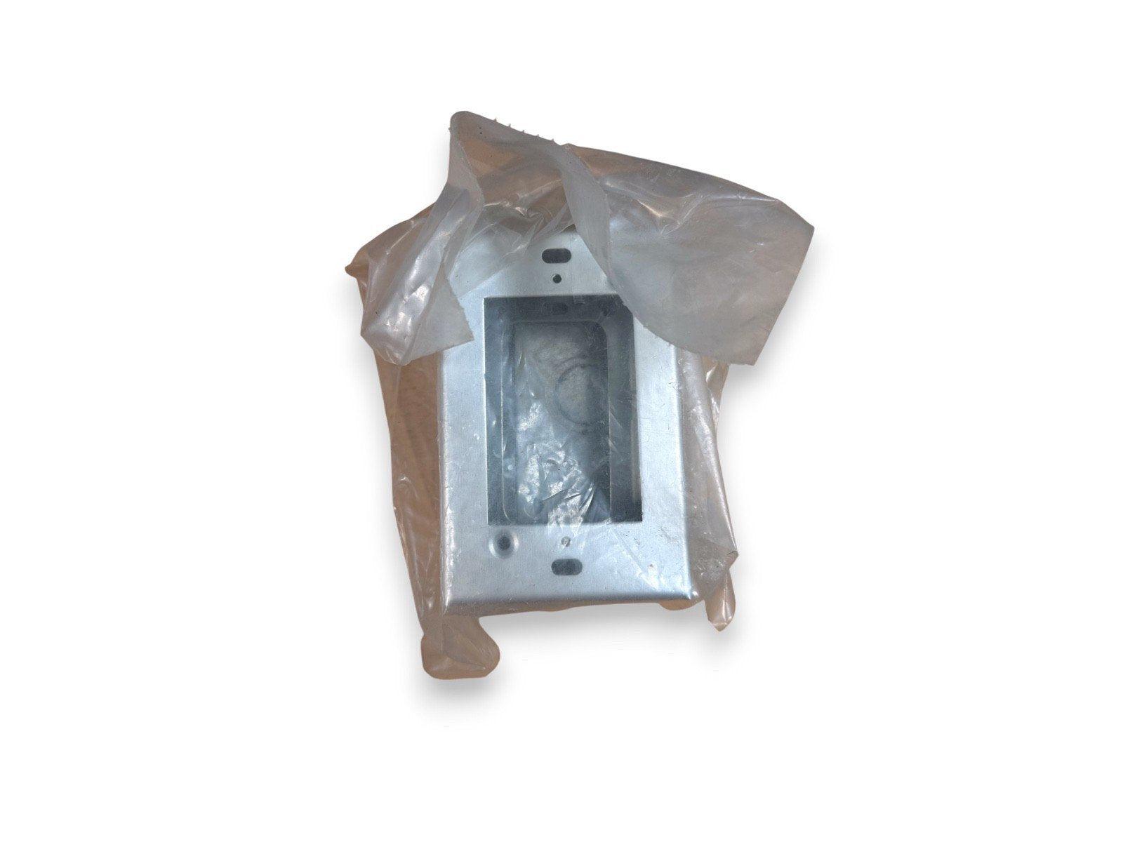 Metal fire alarm pull station cover partially wrapped in plastic, new surplus equipment