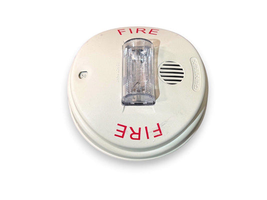 Gentex fire alarm with strobe light and speaker, labeled FIRE for emergency alert systems