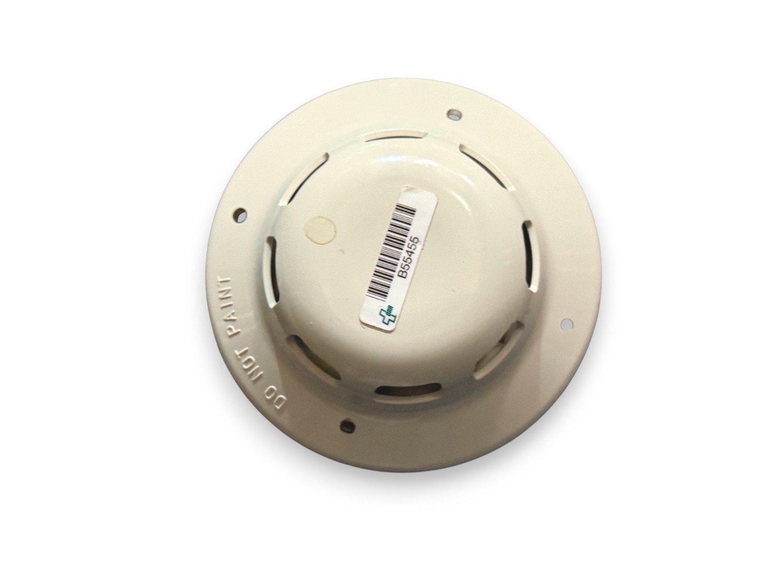 Beige fire alarm detector with barcode label, ceiling-mounted safety device for fire protection systems