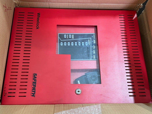 Red Wheelock Safepath fire alarm control panel with digital display and key lock, inside shipping box