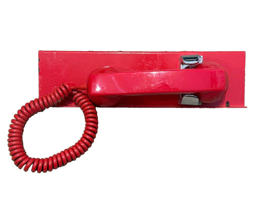 Red fire alarm telephone with coiled cord mounted on wall plate