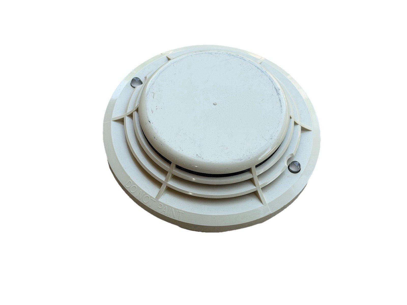 White ceiling-mounted smoke detector with 'DO NOT PAINT' label, fire alarm safety device