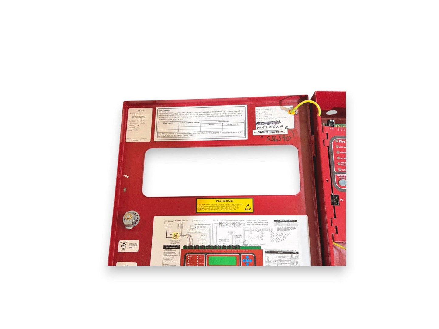 Red fire alarm control panel with wiring diagram and warning labels, used fire safety equipment