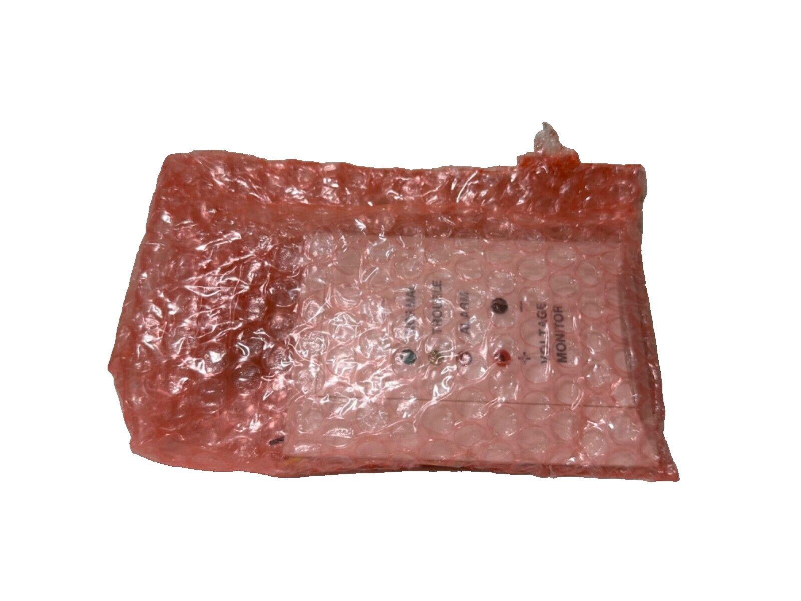 Fire alarm control panel wrapped in pink bubble wrap, showing status LEDs for normal, trouble, alarm, and voltage monitor