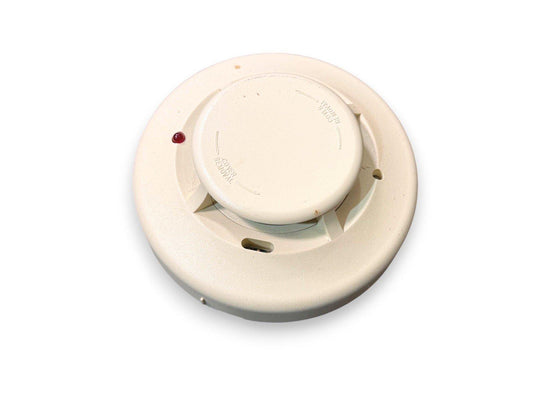 White ceiling-mounted fire alarm detector with red LED indicator, used fire safety equipment