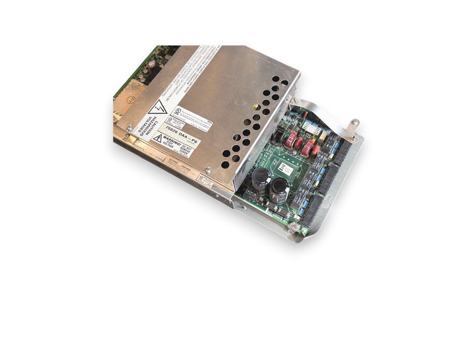 Fire alarm control panel power supply unit with circuit board and warning labels