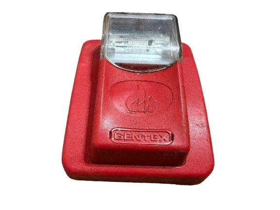 Red Gentex fire alarm pull station with clear cover and flame symbol