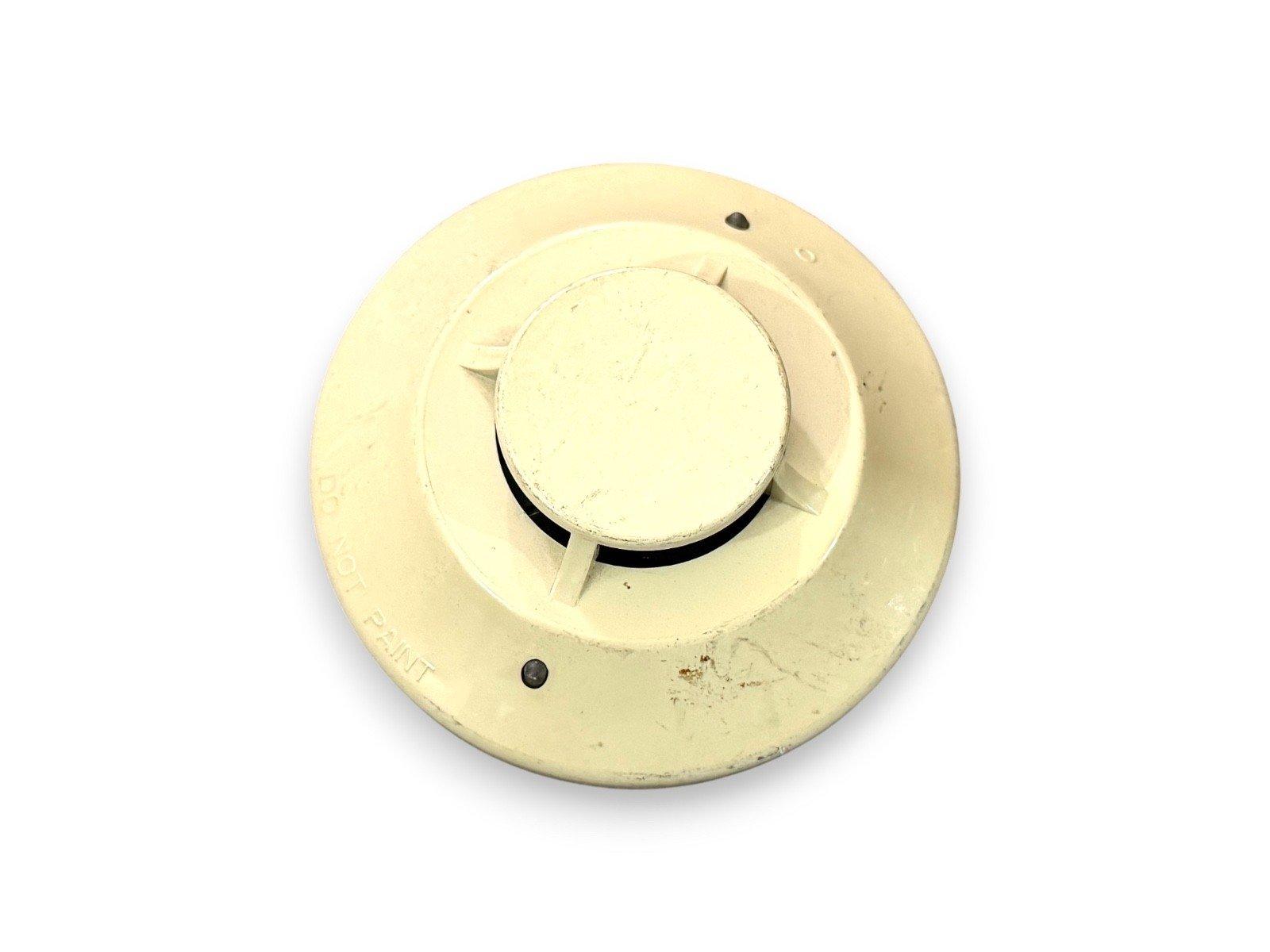Used fire alarm smoke detector with 'DO NOT PAINT' label, off-white ceiling mount device