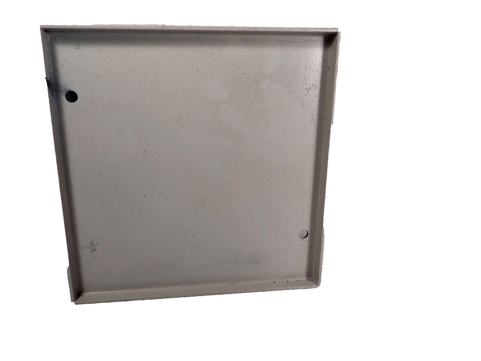 Gray metal fire alarm panel backplate with mounting holes, used fire safety equipment