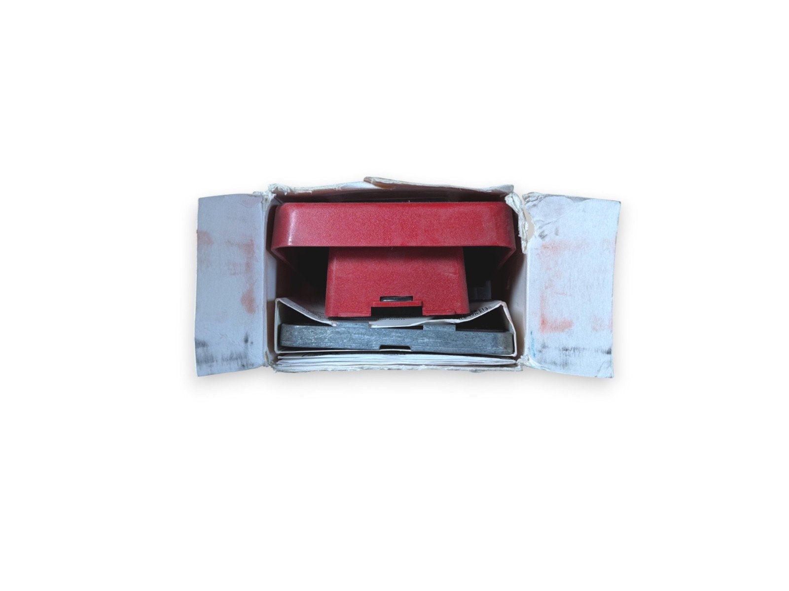 Red fire alarm pull station in open box, used fire safety equipment