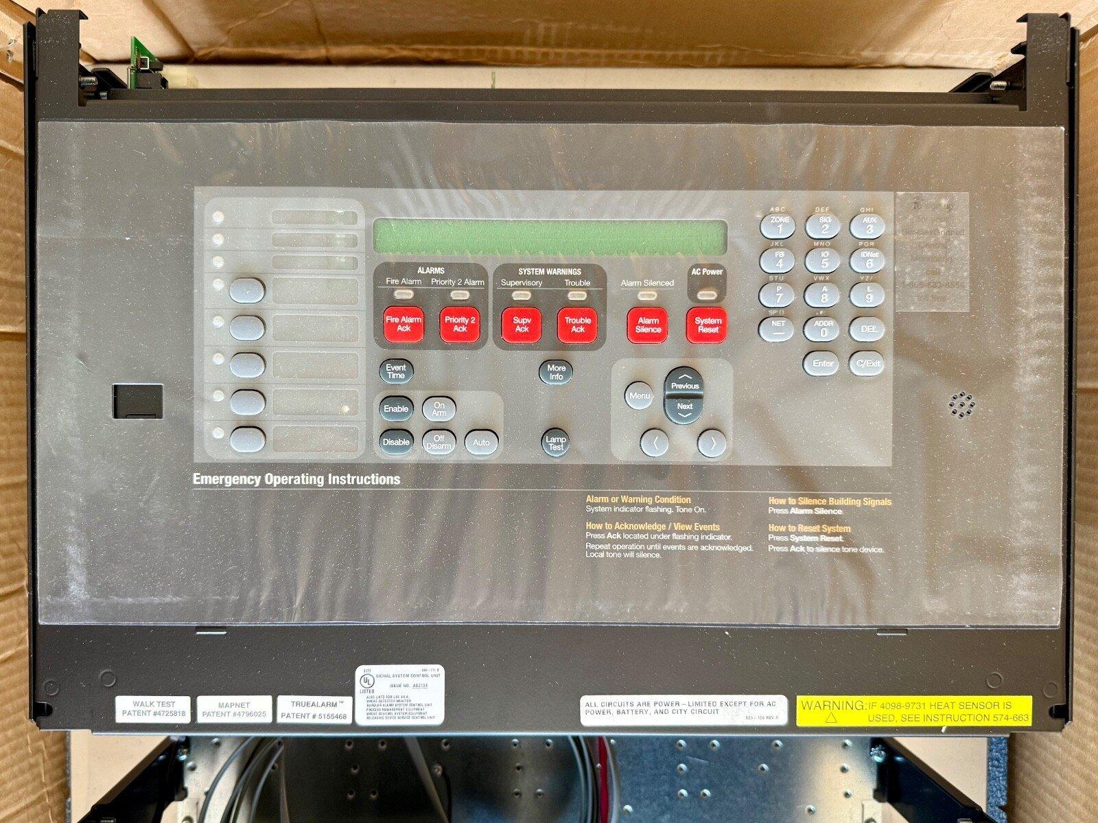 Fire alarm control panel with digital display, red alert buttons, and keypad for emergency system management