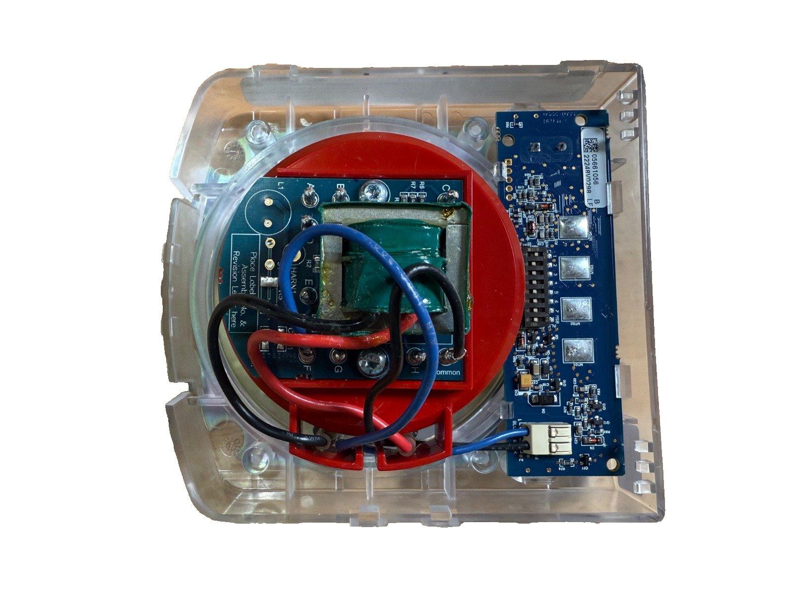 Fire alarm control panel circuit board with red housing and wiring, used fire alarm equipment
