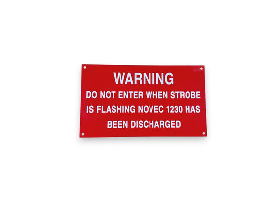 Red warning sign for NOVEC 1230 fire suppression system, cautioning not to enter when strobe is flashing.