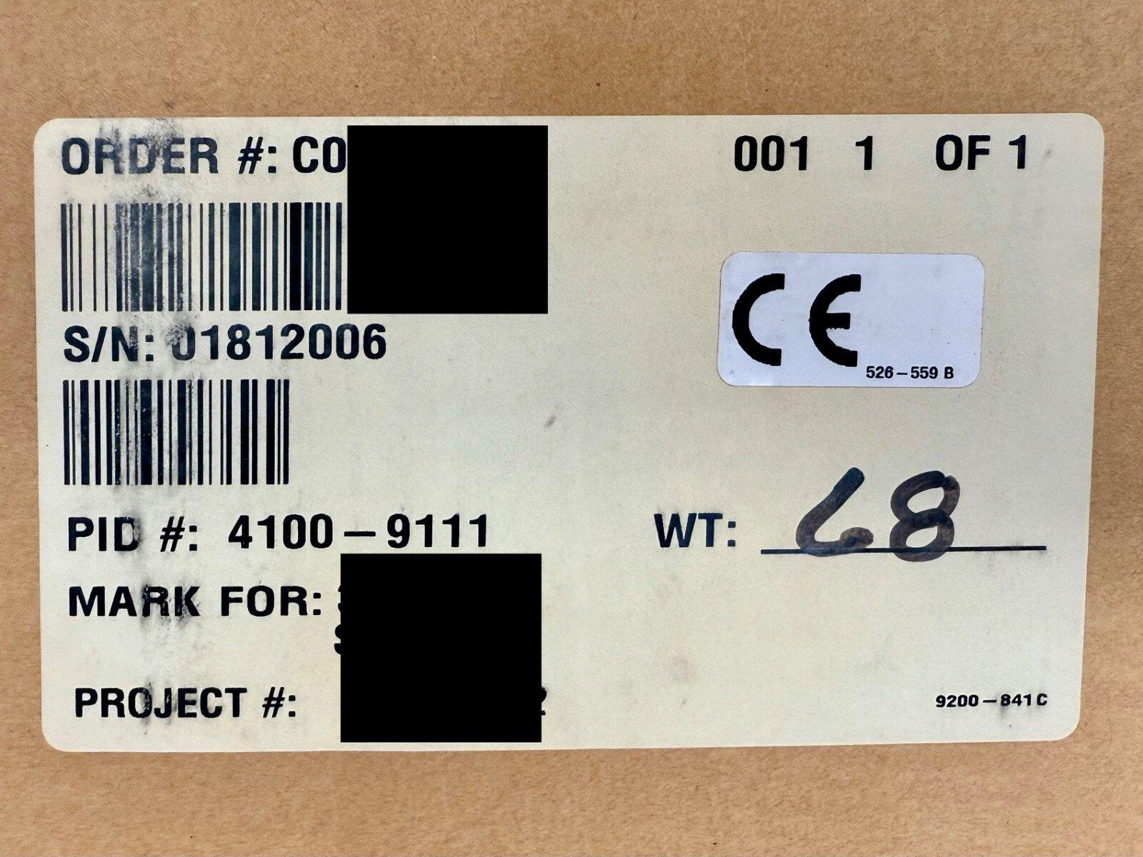 Fire alarm equipment label with CE mark, serial number 01812006, and PID 4100-9111 on cardboard packaging
