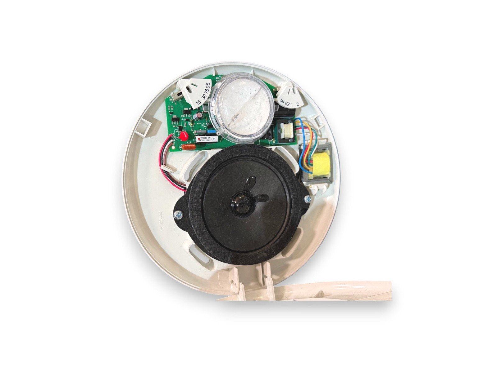 Internal view of fire alarm device with circuit board, speaker, and wiring components