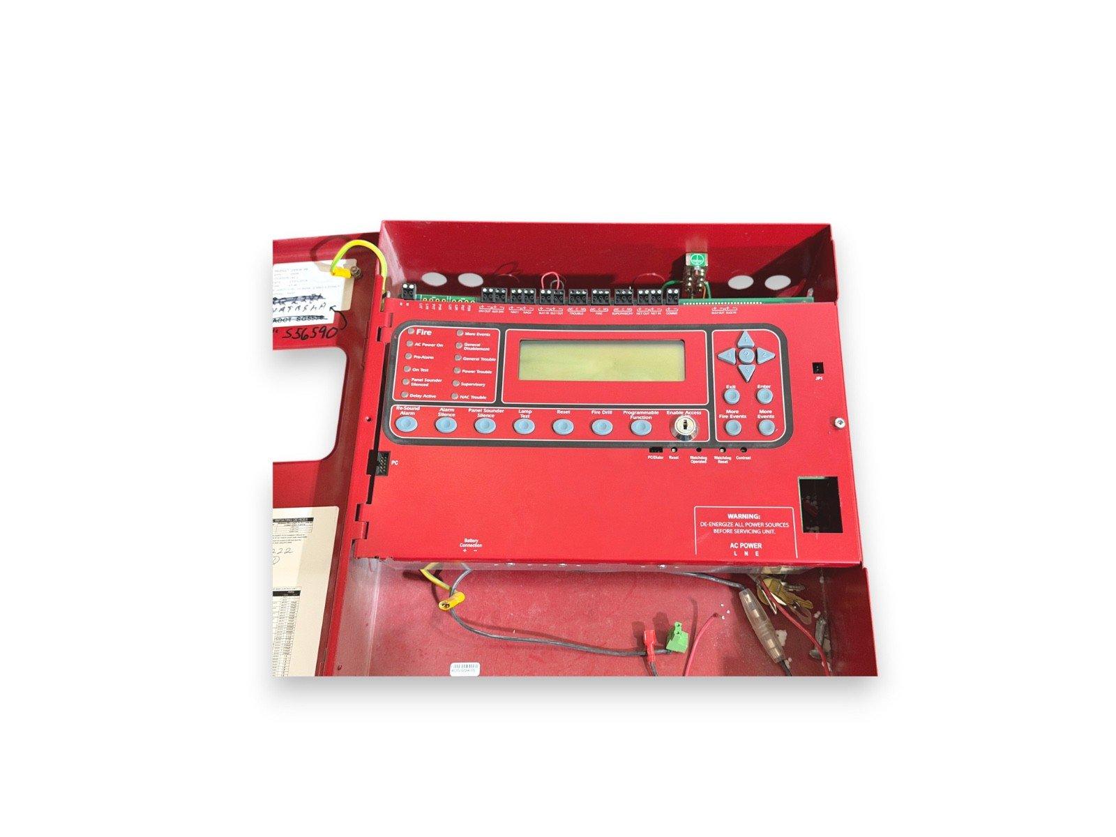Red fire alarm control panel with LCD display, buttons, and wiring for commercial fire safety systems