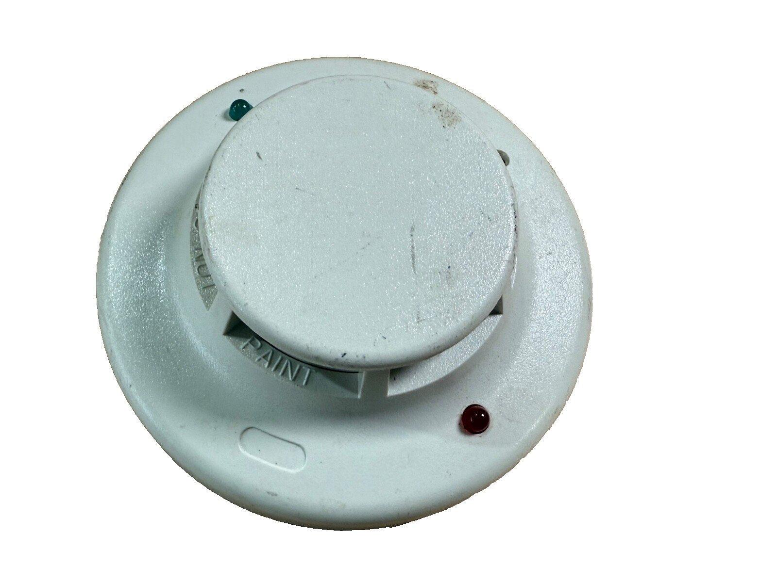 Used white fire alarm smoke detector with green and red indicator lights, showing signs of wear