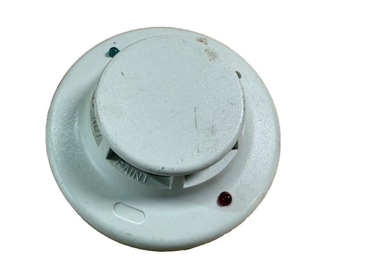 Used white fire alarm smoke detector with green and red indicator lights, showing signs of wear