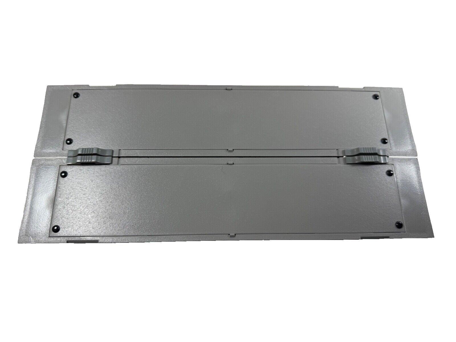 Gray fire alarm control panel enclosure with hinged lid and mounting screws