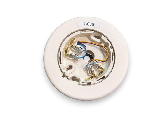 White fire alarm base with wiring terminals and label 1-006, for smoke detector installation