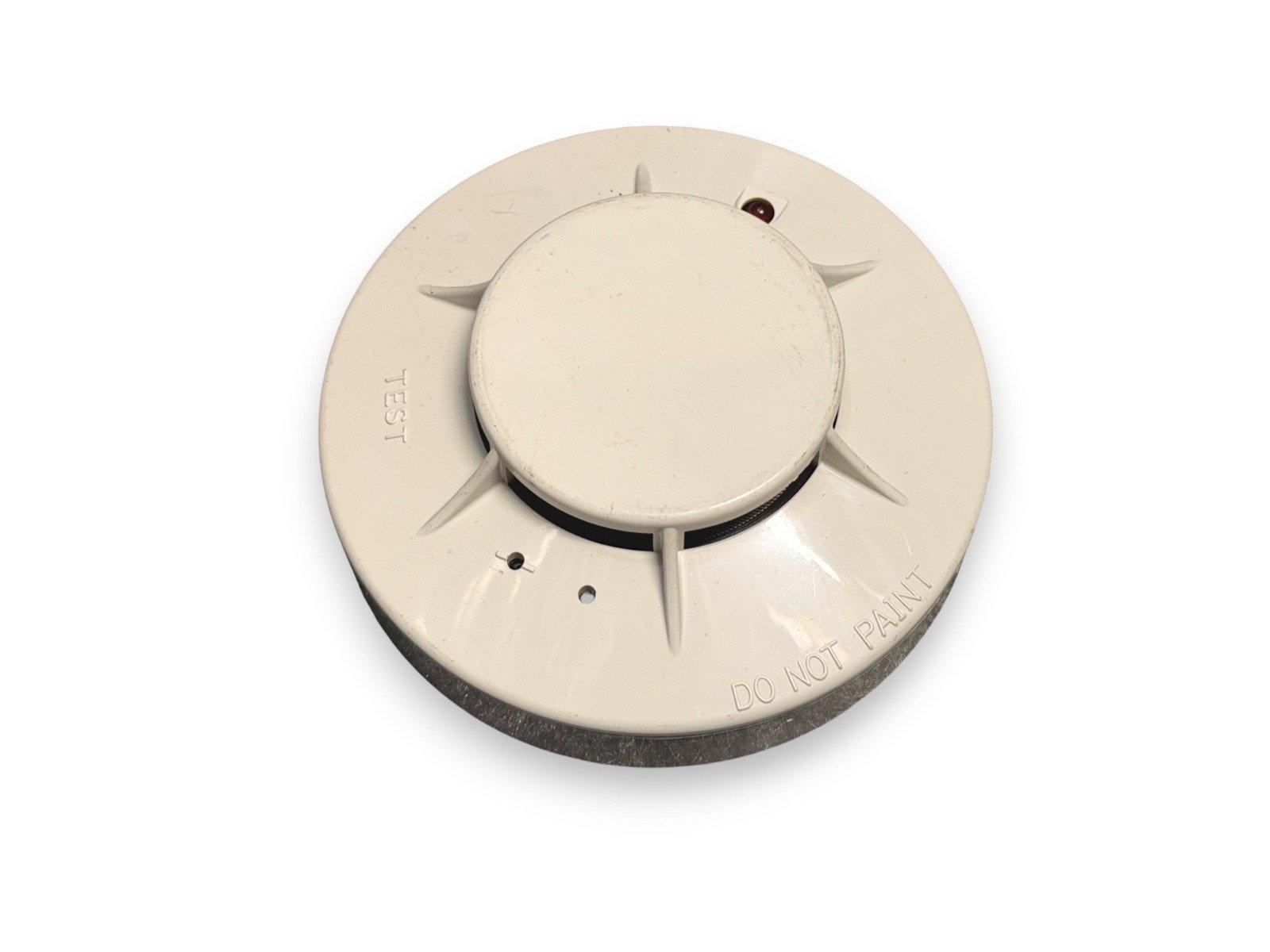 White smoke detector with test button and 'DO NOT PAINT' label, fire alarm safety device