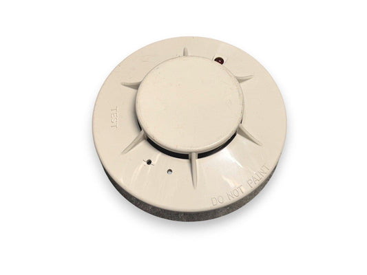 White smoke detector with test button and 'DO NOT PAINT' label, fire alarm safety device