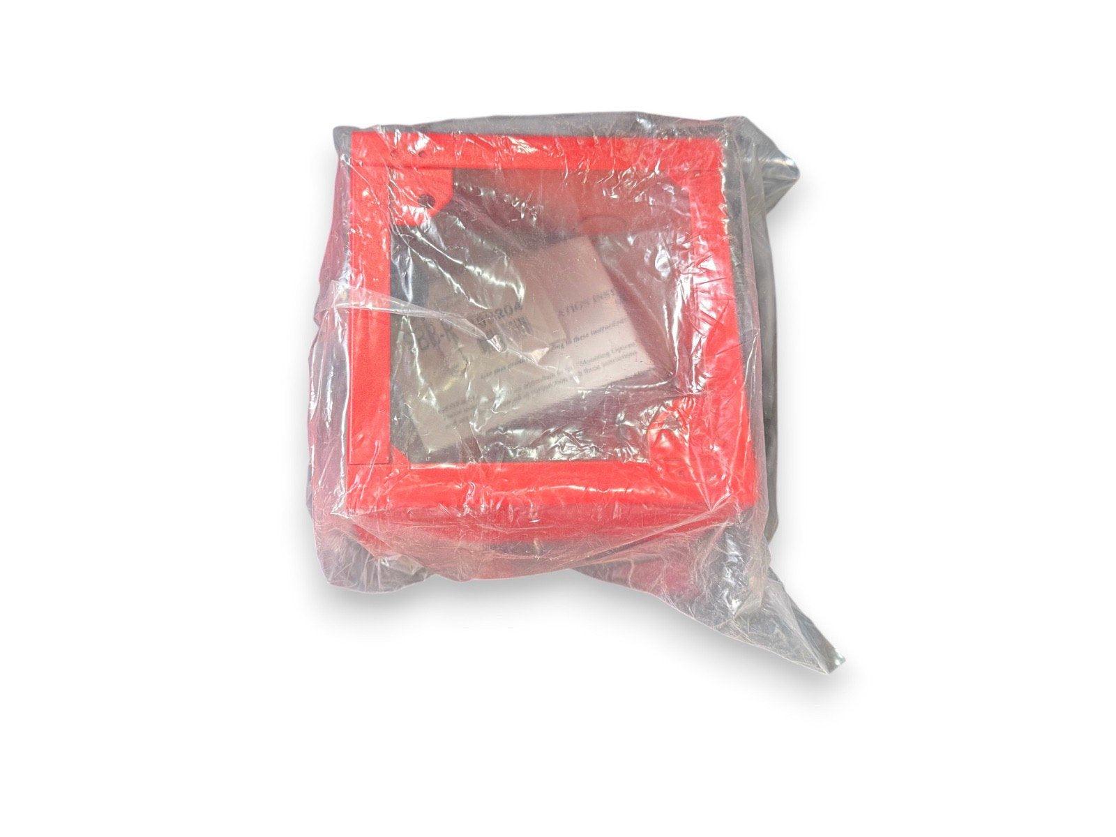 Red fire alarm pull station in clear plastic wrap, new surplus equipment