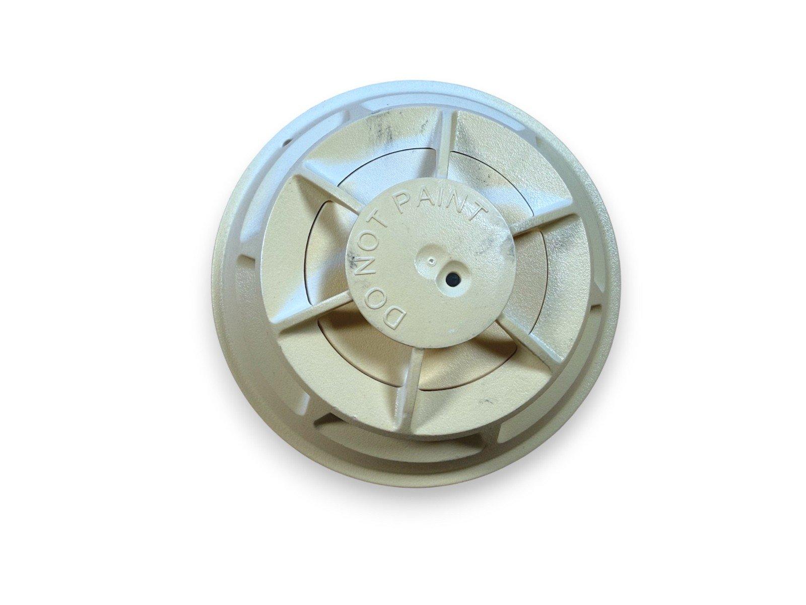 Fire alarm smoke detector base with 'DO NOT PAINT' label, beige plastic housing for ceiling mount